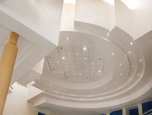 Soffitto moderno con luci incassate e design circolare.
