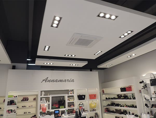 Interno di un negozio con scaffali di borse e scarpe.