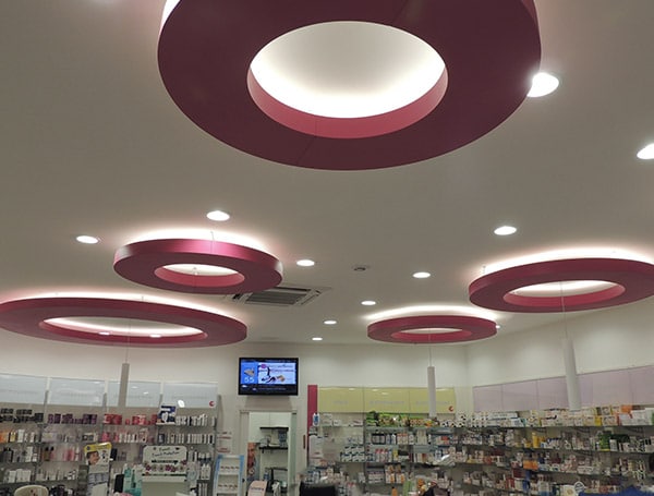 Interno di una farmacia con illuminazione moderna circolare.