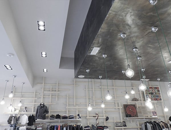 Negozio di abbigliamento con illuminazione moderna e scaffali.