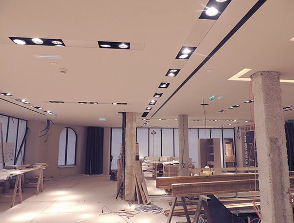 Interno di un edificio in ristrutturazione con luci accese.