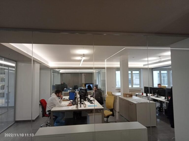 Ufficio moderno con persone al lavoro su computer.