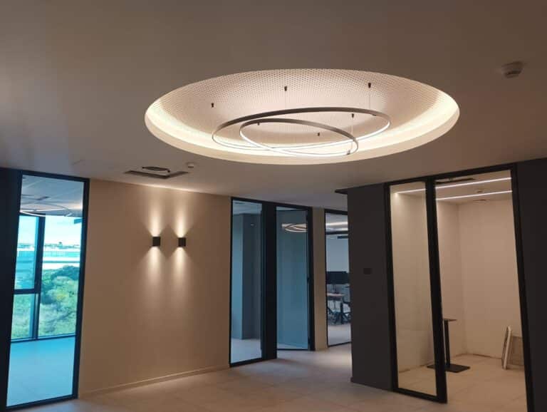Interno moderno con illuminazione circolare e pareti vetrate.